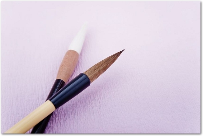 薄紫の和紙に置かれた２本の筆